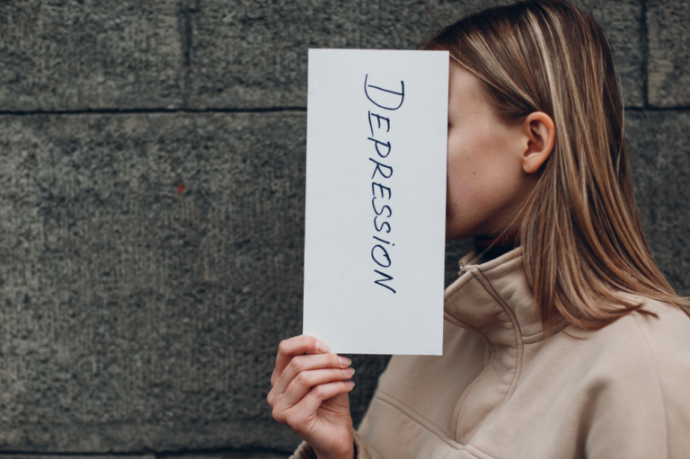 Depression Treatment in Arizona - Woman holding up a paper with the word "depression" in front of her face