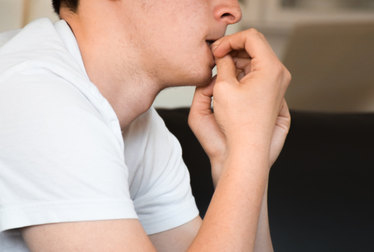 Man biting nails in need of anxiety treatment
