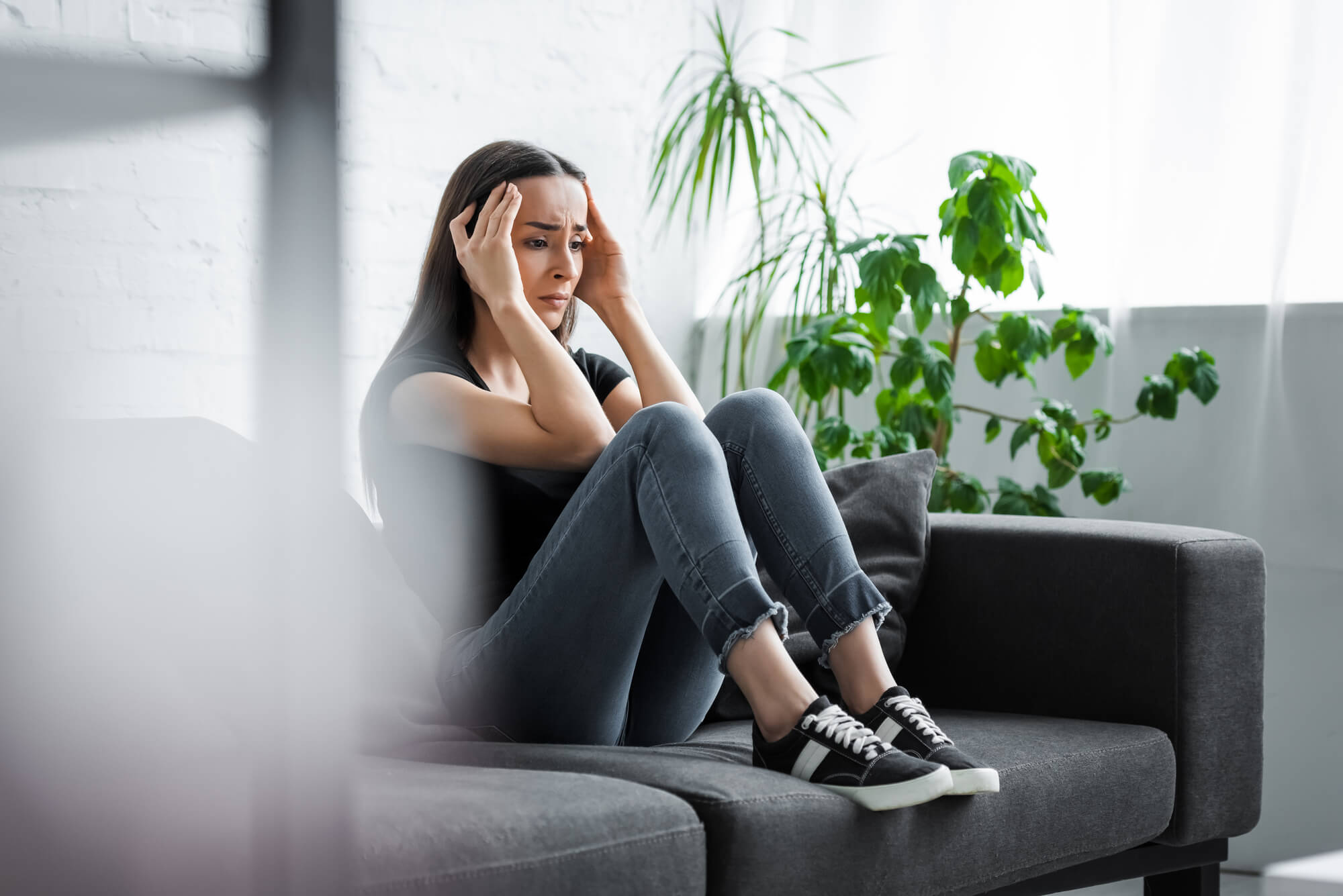 Person sitting on the couch feeling sad or hopeless